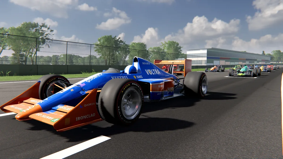 The Classic 1989 car in three-quarter view, blue with an orange front wing